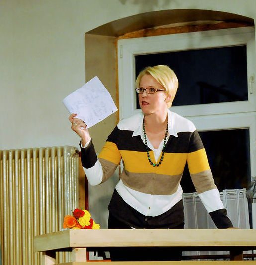 Die Lehrerin Frau Müller hält einen Brief in der Hand, den sie vom Elternbeirat erhalten hat.